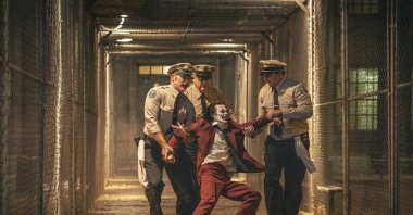 Joaquin Phoenix (foreground C) and Brendan Gleeson (background C) in a scene from "Joker: Folie a Deux." (Warner Bros. via AP Photo)