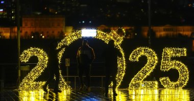 A group of friends take pictures at the 2025 New Year's decorations by the Bosporus, Istanbul, Türkiye, Dec. 29, 2024. (AA Photo)