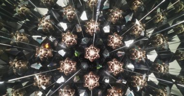 A visitor looks into a kaleidoscope at Paradox Museum Miami in Miami, U.S., Jan. 28, 2025. (AP Photo)