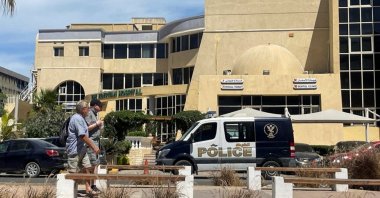 People walk next to an Egyptian police vehicle in front of the hospital where the bodies of foreigners killed when a tourist submarine sank off Egypt's Red Sea coast are kept in Hurghada, Egypt, March 27, 2025. (Reuters Photo)