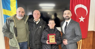 Uğur Ergün (right), head of the Stockholm Botkyrka Turkish Cultural Association, presents father and son with a plaque in recognition of their exemplary actions, in this photo released on Monday, March 31, 2025. (AA Photo)
