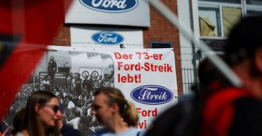The word "Strike" is displayed in the typography of the Ford sign on a banner, as workers rally during a strike by the IG Metall union at a Ford plant, Cologne, Germany, May 14, 2025. (Reuters Photo)