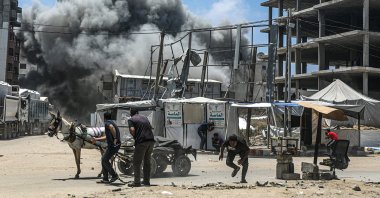 Palestinians try to take cover as smoke rises following an Israeli airstrike west of Gaza City, Palestine, May 23, 2025. (EPA Photo)