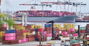 The Seattle Bridge container ship, sailing under the flag of Panama, is seen in the background of stacked containers in the Port of Los Angeles, California, U.S., May 6, 2025. (AFP Photo)