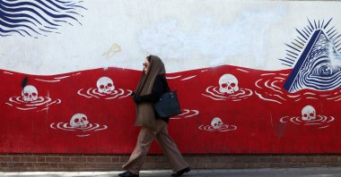 An Iranian woman walks past an anti-U.S. mural near the former U.S. embassy in Tehran, Iran, May 22, 2025. (EPA Photo)