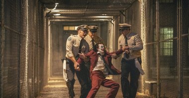 Joaquin Phoenix (foreground C) and Brendan Gleeson (background C) in a scene from "Joker: Folie a Deux." (AP Photo)