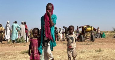 A displaced Sudanese woman, accompanied by children, walks at a camp near the town of Tawila in North Darfur, Sudan, Feb. 11, 2025. (AFP Photo)