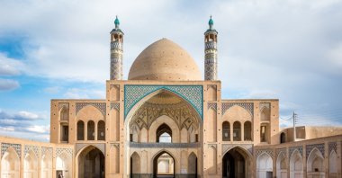 A symmetrical view of the mosaic work and sandstone colored Islamic architecture of the Agha Bozorg mosque in the desert city of Kashan, Iran. (Shutterstock Photo)