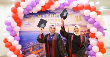 Mother, Aycan Özonay (R), and her daughter, Şevval Özonay, raise their graduation caps in celebration after completing their degrees together, Mardin, Türkiye, May 29, 2025. (AA Photo)