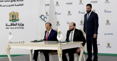 Syrian President Ahmed al-Sharaa stands behind Syrian Energy Minister Mohammed al-Bashir (R) and Kalyon Holding Chairman Orhan Cemal Kalyoncu during a signing ceremony of the Syrian government with four companies to expand the country's electrical grid by 5,000 megawatts, Damascus, Syria, May 30, 2025. (EPA Photo)