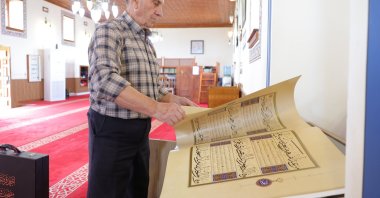 Kasem Hafizi, the mosque's 78-year-old imam, shows the preserved Quran at the mosque, Tirana, Albania, May 31, 2025. (AA Photo)