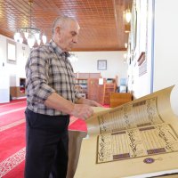 Kasem Hafizi, the mosque's 78-year-old imam, shows the preserved Quran at the mosque, Tirana, Albania, May 31, 2025. (AA Photo)